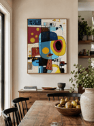 Modern abstract face painting styled in an open-plan dining room with warm wood furniture