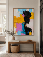 Bold colorful woman wall art above an entryway console in a contemporary artistic foyer