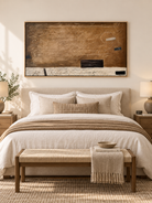 Wide caramel brown wabi-sabi abstract painting displayed above the bed in a warm neutral bedroom