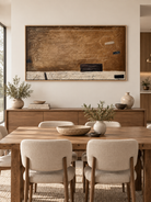 Large earth tone abstract wall art displayed in an open dining room with walnut furniture and natural stone