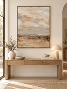Large vertical beige abstract landscape wall art displayed above an entryway console in a wabi-sabi interior