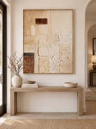 Vertical neutral geometric abstract painting displayed above a console in a contemporary entryway