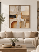 Large neutral textured geometric wall art displayed above a sofa in a warm modern organic living room