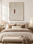 Cream minimalist geometric abstract painting displayed above a bed in a warm neutral contemporary bedroom