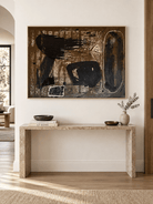Large horizontal abstract wall art displayed above a console in a modern entryway