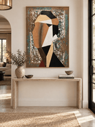 Vertical abstract woman portrait with geometric shapes displayed above a console in a contemporary entryway