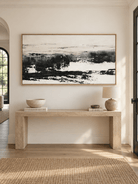 Minimalist black and white abstract wall art displayed above a long console in a contemporary entryway