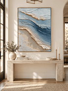 Vertical textured seascape painting in ocean blue and ivory displayed above a console in a coastal entryway