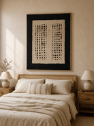 Black and ivory wabi-sabi textured abstract painting displayed in a warm neutral minimalist bedroom