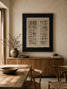 Large black and beige geometric relief wall art displayed in an organic modern open dining room