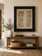 Vertical black and ivory textured wall art displayed above an entryway console in a wabi-sabi interior