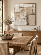 Large beige plaster-style wall art displayed in an organic modern open dining room with natural wood furniture