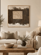 Large dark brown textured wall art displayed above a beige sofa in an organic modern living room