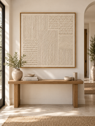 Square ivory textured wall art displayed above an entryway console in a minimalist Japandi interior