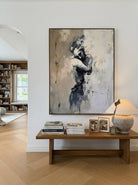 Hand-painted abstract figurative canvas painting featuring a solitary female figure in neutral beige, gray, and black tones with expressive textured brushstrokes for modern bedroom wall decor.