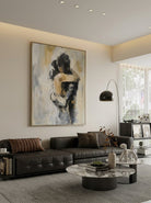 Hand-painted abstract romantic couple painting featuring two embracing figures in neutral beige, gray, black, and ivory tones with textured contemporary brushstrokes on canvas.
