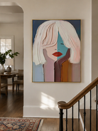 Geometric abstract woman wall art above an entryway console in a contemporary foyer