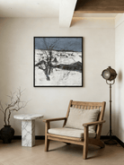 Hand-painted winter landscape oil painting featuring a black tree in a snowy field under a dark grey sky with heavy texture.