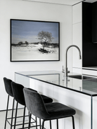  Large horizontal hand-painted minimalist oil painting of a single dark tree in a vast white snowfield under a soft blue sky.