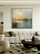 Large square hand-painted impressionist painting of a golden sun reflecting on a blue sea with heavy impasto texture by Evelyn Li in a modern living room.