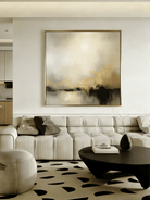 Large square hand-painted abstract painting with heavy 3D gold texture and black drip effect by Evelyn Li in a modern minimalist living room.