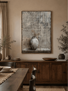 Neutral pottery still life painting displayed in an organic modern open-plan dining room