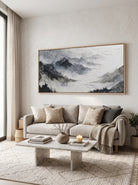 Large horizontal monochrome textured landscape canvas art above minimalist sofa in modern living room
