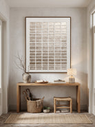 Architectural gold relief canvas painting hung above minimalist console table in modern Japandi entryway