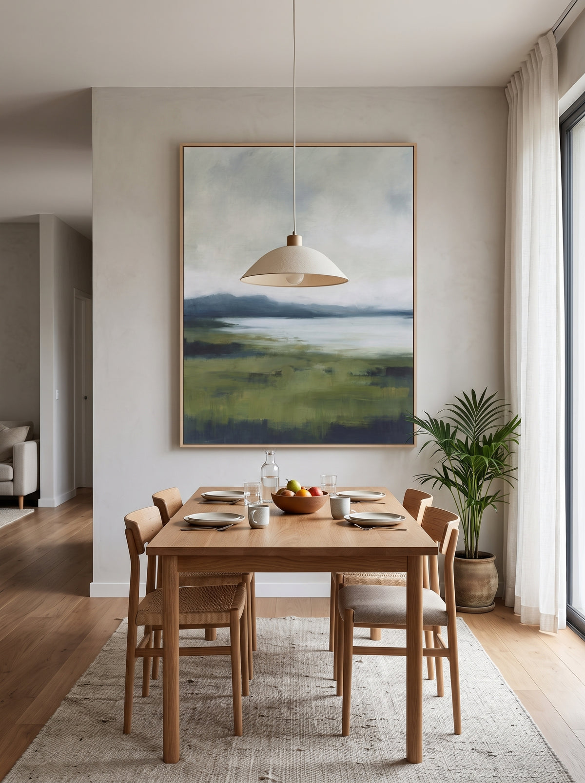 Oversized vertical moss green landscape canvas art displayed on an open-concept dining room wall
