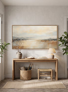 Framed panoramic coastal horizon canvas painting above console table in bright minimalist entryway
