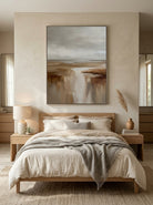 Serene warm earth tone coastal horizon canvas artwork hanging above a contemporary Japandi bedroom headboard