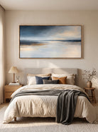 Calming blue and warm neutral seascape painting by Evelyn Li hanging above bed in serene master bedroom