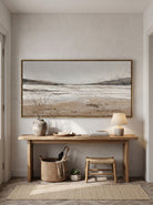 Minimalist horizontal coastal horizon canvas painting mounted above wooden console table in bright entryway