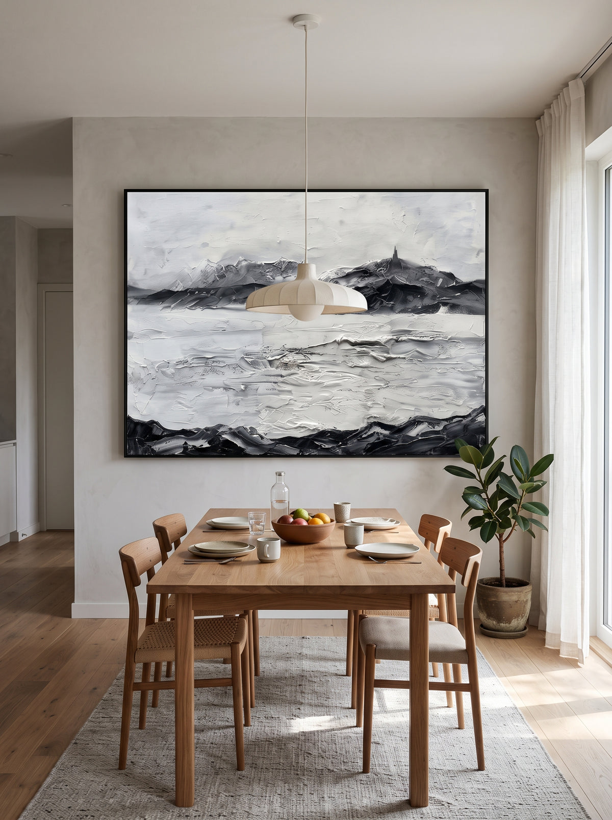 Large horizontal black and white coastal mountain textured wall art displayed on an open-concept dining room wall