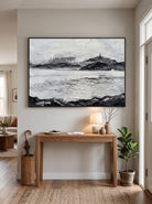 Framed textured winter mountain landscape painting styled above a wooden console table in a contemporary entryway
