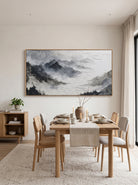 Framed panoramic wabi-sabi mountain peak artwork displayed in neutral open-concept dining room