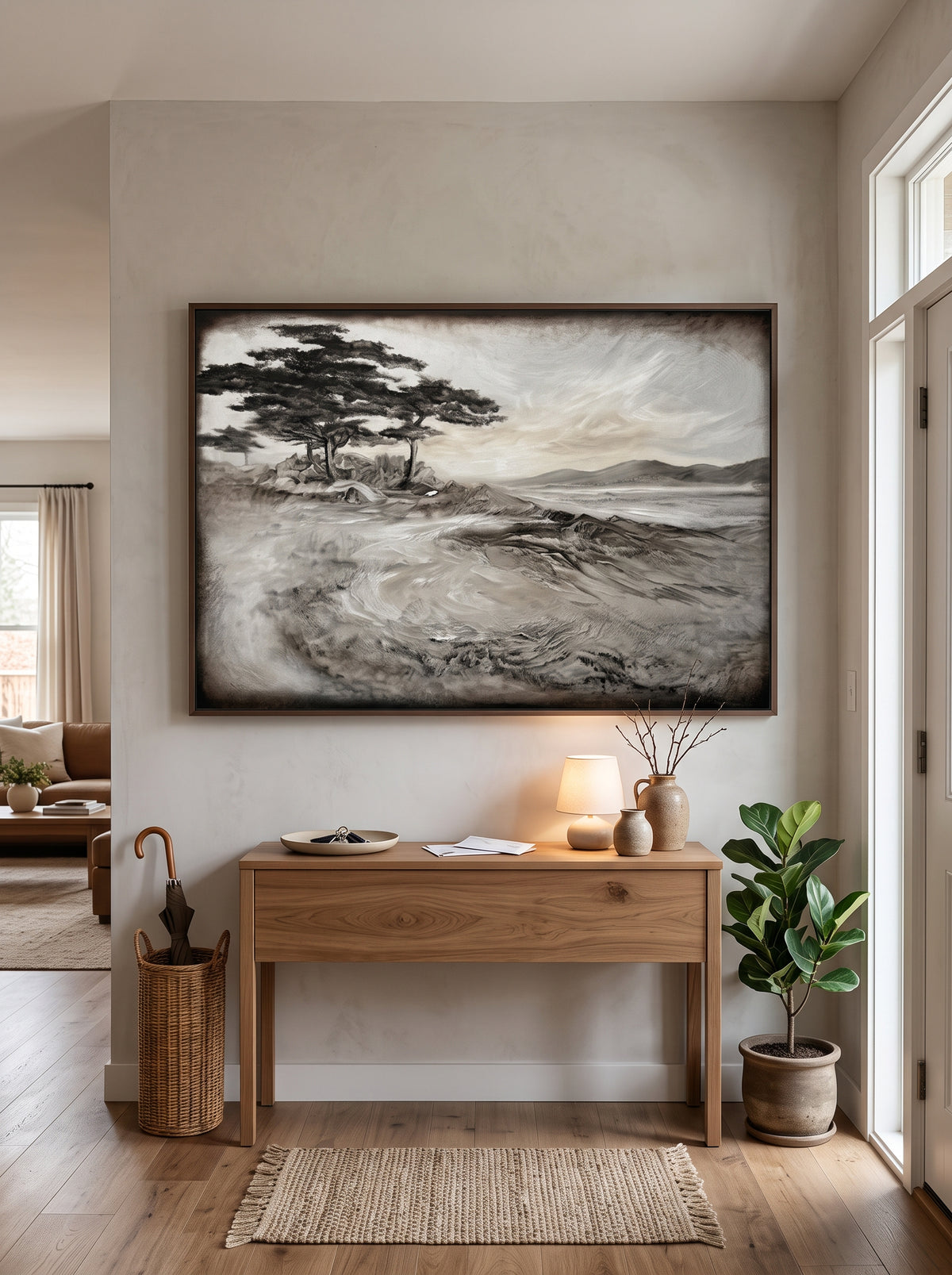 Panoramic textured coastal pine tree painting styled above a wooden console table in a contemporary entryway