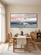 Textured abstract ocean seascape painting displayed in a modern open dining room with neutral interior décor.