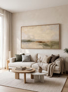 Neutral Wabi-Sabi abstract landscape painting displayed above a sofa in a warm modern living room.