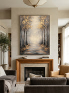 Vertical textured forest landscape painting with gold leaf foliage above a modern neutral sofa