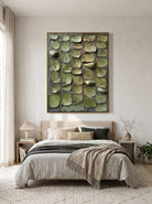 Tactile moss green organic relief artwork by Eliot Vermeer hanging in calming wabi-sabi neutral bedroom
