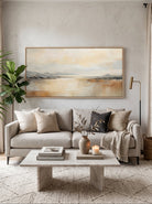 Large panoramic warm neutral landscape canvas wall art above modern sofa in open-plan living room