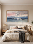 Hand-painted blue and pink coastal seascape wall art displayed above the bed in a calm contemporary bedroom.