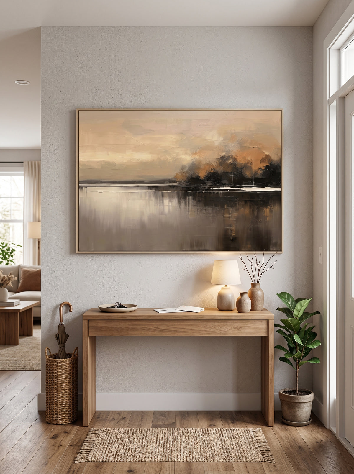 Framed textured dusk waterscape painting styled above a wooden console table in a contemporary entryway