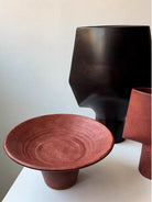 artisan ceramic geometric sculptures in matte rust red and black, modern minimalist architectural home decor on a white background.