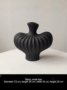 sculptural fluted ceramic vases in black, cream, and terracotta rust, organic heart-shaped silhouette, artistic home decor.
