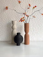ribbed geometric ceramic vases in black, sand, and terracotta, minimalist organic pottery for shelf styling.