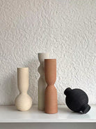 ribbed geometric ceramic vases in black, sand, and terracotta, minimalist organic pottery for shelf styling.