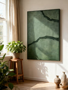 Black and green abstract textured river canvas art displayed on a modern living room wall