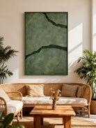 Black and green abstract textured river canvas art displayed on a modern living room wall